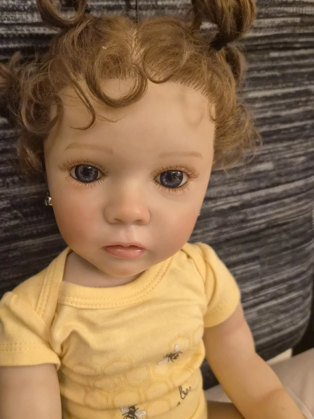 Reborn Baby Doll in Yellow Onesie with Curly Brown Hair
